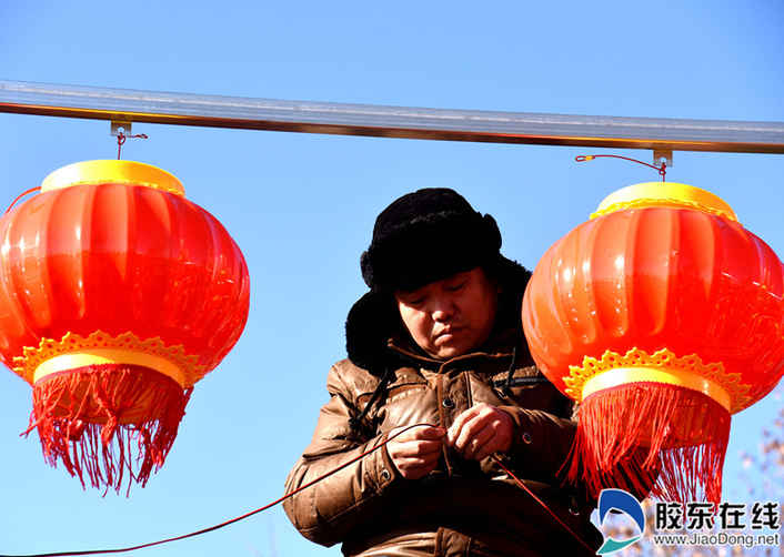 施工人員正在萊山區(qū)虞美人廣場(chǎng)安裝燈籠