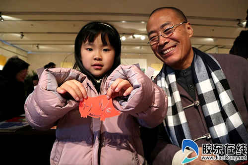 小朋友展示新鮮出爐的福豬剪紙(苗偉攝)